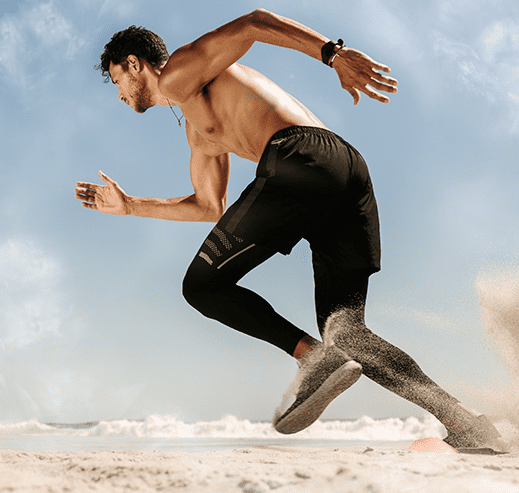 man is sprinting on a sandy beach