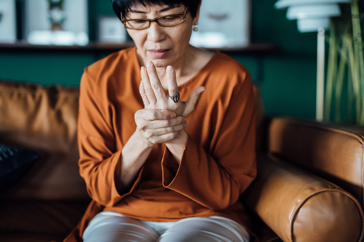 A woman rubbing and holding her hand in pain