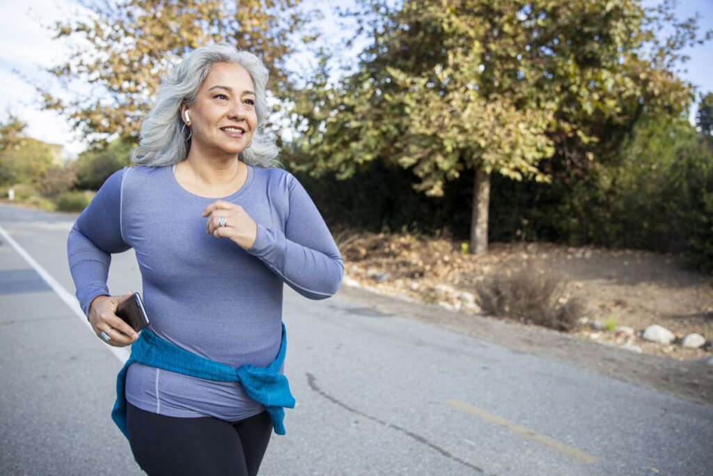 A woman with gray hair running outside