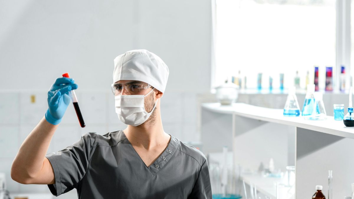 A man in a lab coat is holding a test tube, focused on his scientific experiment in a laboratory setting.