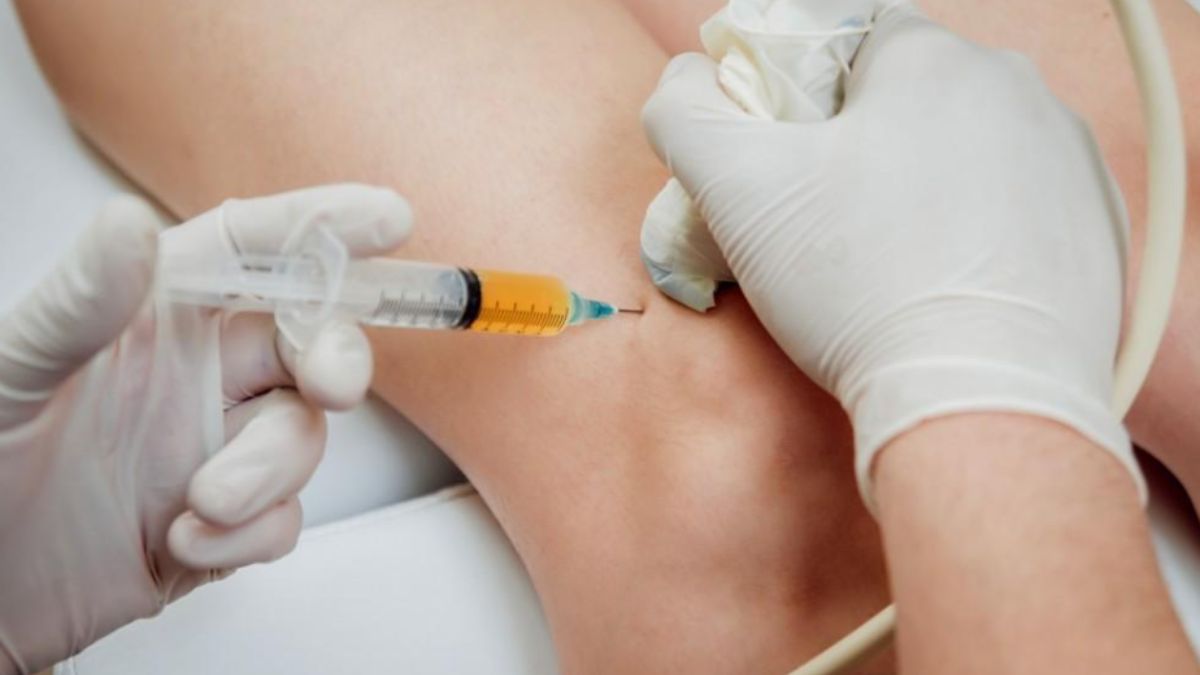 A person receiving a leg injection, demonstrating a medical procedure in a clinical setting.