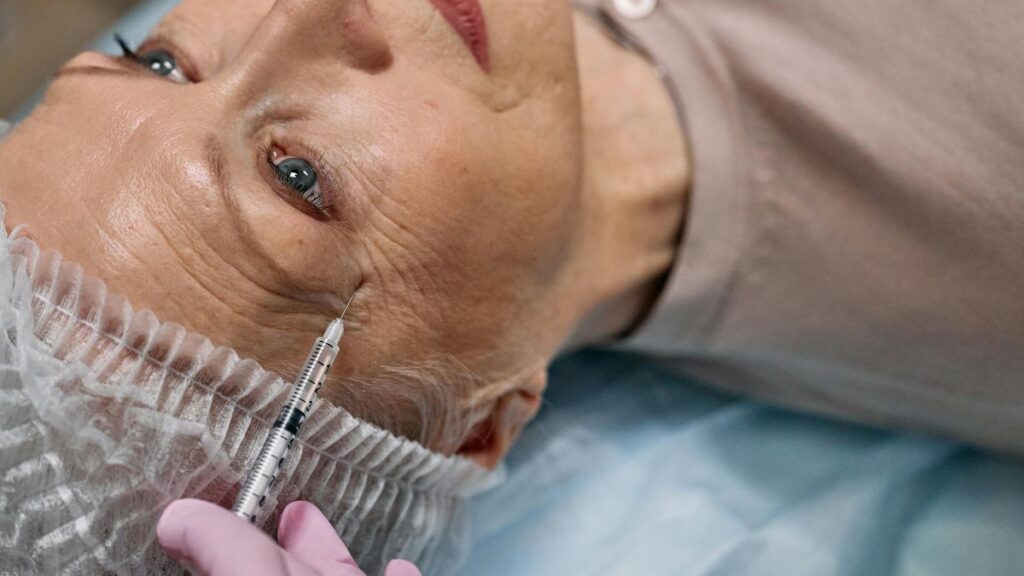 A woman receiving a facial injection, showcasing a professional setting and focused attention on her skincare treatment.